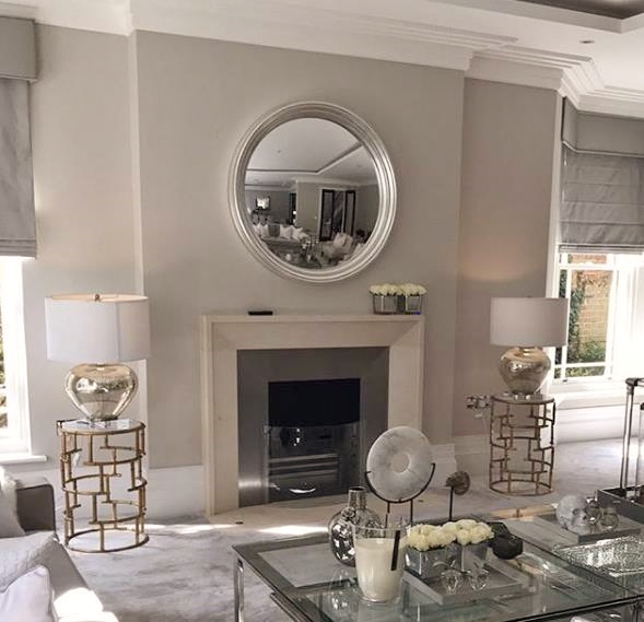 large silver leaf convex mirror hanging above fireplace image